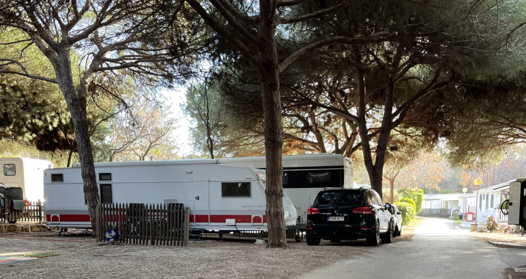 Camping Cabopino, asuntovaunu ja auto pinjapuiden alla Espanjassa.